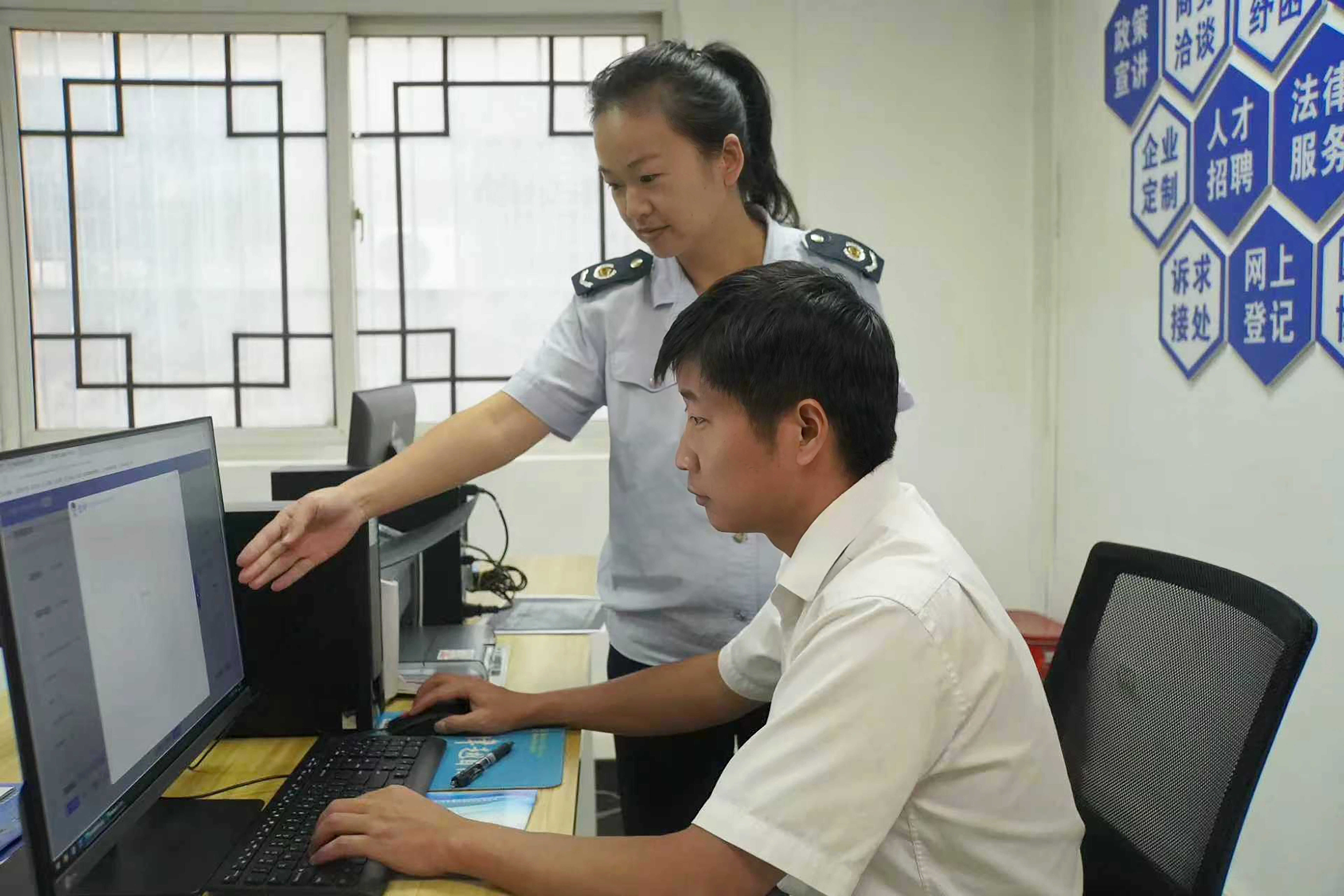 税务干部在办税服务厅辅导纳税人通过电子税务局申请发票提额(摄影 唐军).jpg